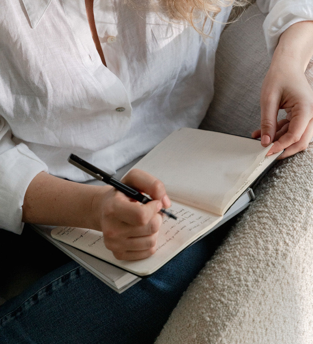 A woman writing notes in a notebook