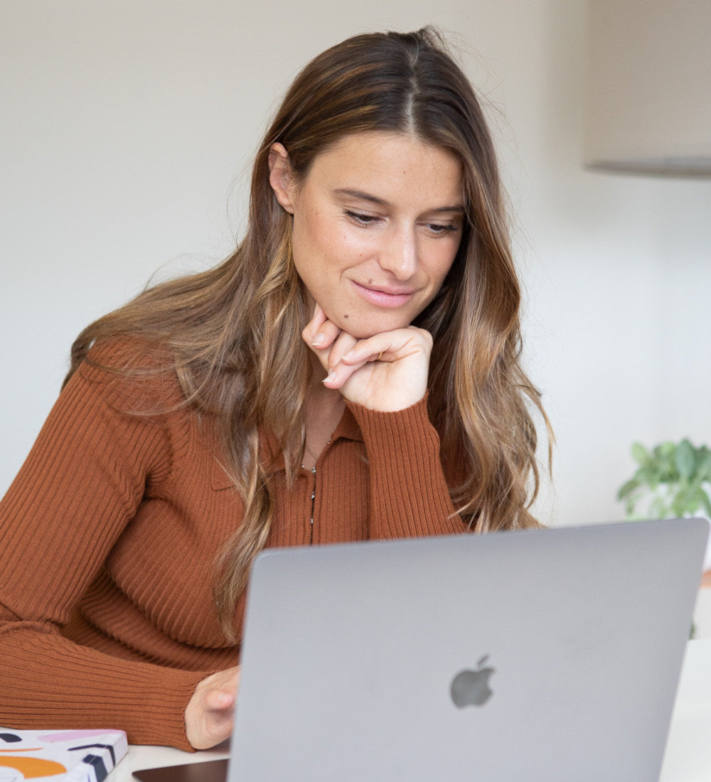 India Drinan working at her laptop